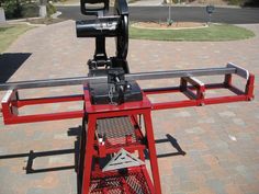 a machine that is sitting on top of a red stand in the middle of a brick walkway