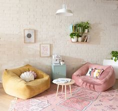 a living room with two bean chairs and a rug in front of a brick wall