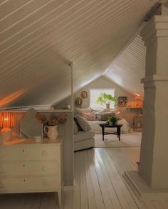 an attic bedroom with white walls and wood floors