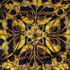 a black, yellow and brown scarf with gold chains on it's center piece