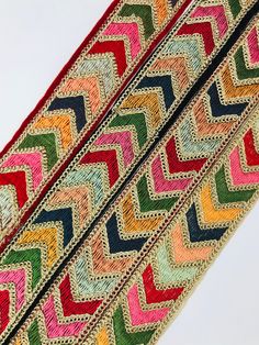 multicolored braiding on the side of a piece of cloth with white background