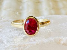 Classic Red Oval Birthstone Ring, Classic Oval Red Birthstone Ring, Fine Jewelry Oval Solitaire Ruby Ring, Oval Ruby Solitaire Ring, Classic Oval Rings With Bezel Setting, Classic Oval Ring With Bezel Setting, Oval Solitaire Ruby Ring Gift, Heirloom Oval Ruby Birthstone Ring, Oval Ruby Ring For Anniversary