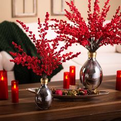 red flowers are in vases on a table with candles and other decorations around it