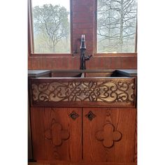 a wooden sink in front of a window with an intricate design on the side panel