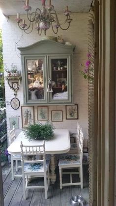 a dining room table and chairs with pictures on the wall above it, next to a dog bowl