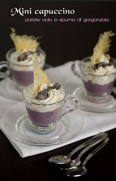 two cups filled with dessert sitting on top of a table