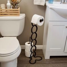 a white toilet sitting in a bathroom next to a wooden basket filled with toilet paper