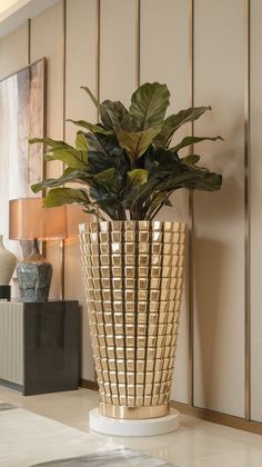 a potted plant sitting on top of a white table next to a lamp and two lamps