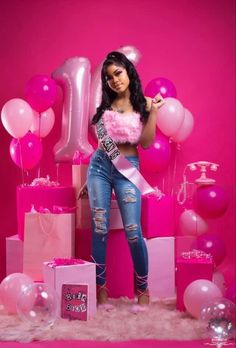 a woman is posing with balloons and presents