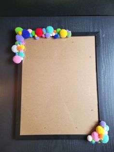 a frame with pom - poms on top of it sitting on a table