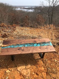 a wooden bench sitting on top of a dirt field