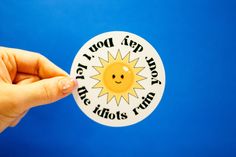 a person holding up a sticker that says, you're happy and the sun is