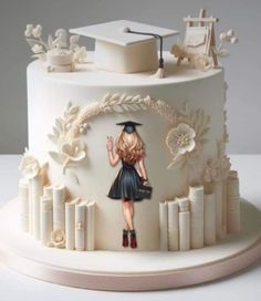 a white cake with a girl in a graduation cap and dress on it's side