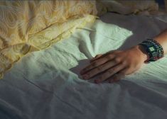 a person's hand on top of a bed