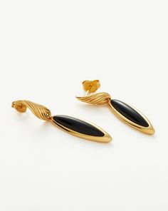 Wavy Ridge Gemstone Double Drop Earrings 18ct Gold Plated/Black Onyx. These Double Drop Earrings Feature Black Onyx Gemstones — Known for Protection — and Twisted Ridge Detailing in their Sculptural Design. Let this Delicate Pair Dangle Solo or Style with Mini Hoops and Studs for an Instant Ear Stack. Metal: 18Ct Recycled Gold Plated on Brass Width: 5mm - 7. 7mm Length: 41. 1mm Gemstone: Black Onyx Weight: 5. 6g Product Code: Wr-G-E6-Bx Gold Onyx Earrings For Evening, Elegant Onyx Earrings, Formal Pierced Onyx Earrings, Formal Onyx Earrings, Luxury Onyx Drop Earrings, Formal Onyx Gemstone Earrings, Classic Black Enamel Earrings For Formal Occasion, Black Polished Finish Fine Jewelry Earrings, Evening Onyx Jewelry In Yellow Gold