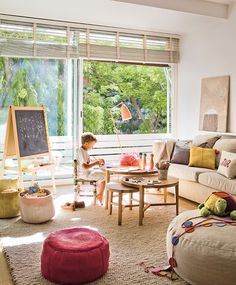 a living room filled with furniture and a chalkboard