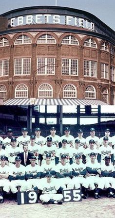 the baseball team is posing for a group photo in front of an old brick building