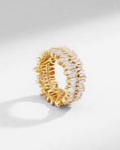 This 18K gold eternity band is a breathtaking display of precision and luxury. It features 3.63 carats of stunning baguette white diamonds, expertly set in the Suzanne's signature uneven design. The diamonds are a mix of differently sized baguette, adding depth and dimension to the design. Details 18k yellow gold, rose gold or white gold 3.63 carats of white diamond baguettes 11mm width Ref: BAR768 Luxury Baguette Cut Cubic Zirconia Eternity Band, Luxury Baguette-cut Eternity Band With Diamond Accents, Gold Baguette Cut Ring For Everyday Luxury, Luxury Moissanite Baguette Cut Eternity Band, Luxury White Baguette Cut Eternity Band, Everyday Luxury Gold Baguette Cut Ring, Elegant Diamond White Eternity Band With Baguette Diamonds, Elegant Eternity Band With Baguette Diamonds In Cubic Zirconia, Elegant Cubic Zirconia Eternity Band With Baguette Diamonds