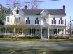 a large white house sitting on the side of a road