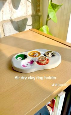 an air dry clay ring holder is sitting on a table next to a book shelf