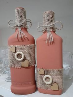 two pink bottles with burlocks and hearts on them sitting next to each other