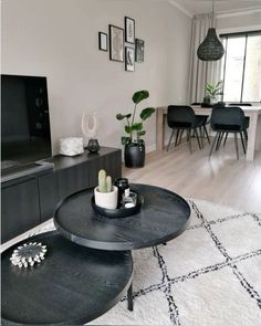 a living room filled with furniture and a flat screen tv on top of a wooden table