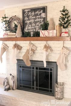 christmas stockings hung on the mantel in front of a fireplace