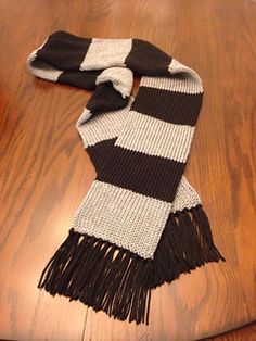 a black and white scarf sitting on top of a wooden table