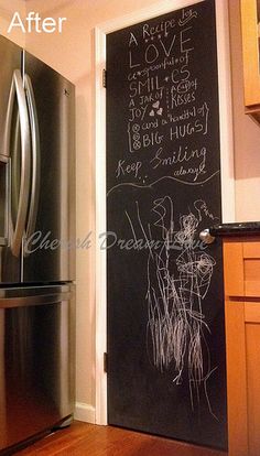 a kitchen with a refrigerator and chalkboard on the wall