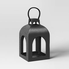 a black candle holder with a handle on the top and bottom, sitting in front of a white background