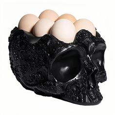 a skull shaped egg holder with six eggs in it's shell, on a white background