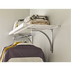 a white shelf with clothes hanging from it's sides and a yellow blanket on the other side