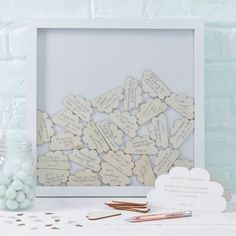 a white frame filled with lots of wooden hearts next to other items on a table