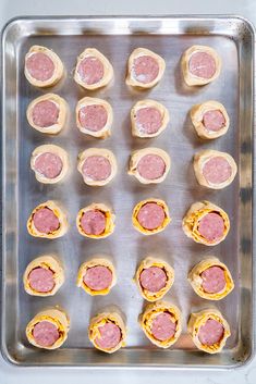 the tray is full of mini sandwiches with meat and cheese on them, ready to go into the oven