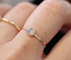 This ring is so dreamy!  Opal is set in a bezel and measures 4mm. Each opal picks up colors of tones of blue, purple, pink, fire, and yellow in the light. Each opal is unique. The batch I have is very colorful. Round band measures 1.3mm.  6 Diamonds are Pave set into the band (3 on each side)  Each diamonds measures 1mm. (.03 ct total)  Available in 14K Yellow, Rose and White gold. *** Please note, All items are made when ordered. Please check policies for current processing times.***  Proces... Diamond Bezel Ring, Ring Opal, Bezel Ring, Minimal Jewelry, Women's Jewelry And Accessories, Cute Rings, October Birthstone, Delicate Jewelry, Ring Dainty