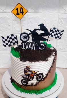 a birthday cake decorated with dirt bike and checkered flags