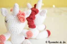 two crocheted unicorns sitting next to each other