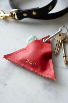 a keychain with a red leather pouch and two keys