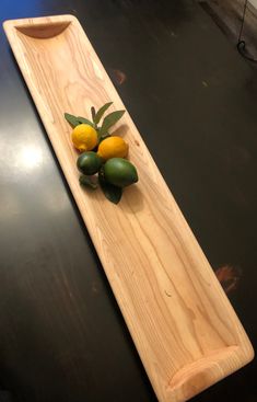 a wooden tray with lemons and avocado on it sitting on a table