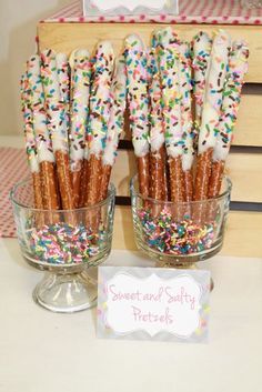 there are many sprinkles on the sticks in this glass bowl and sign