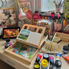 an artist's desk with lots of art supplies on it