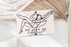 a piece of paper with a drawing of a woman sitting on top of a surfboard