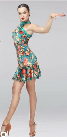 a woman in a floral dress is posing for the camera with her arms out and legs crossed