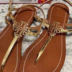 Nwt Gold Tory Burch Sandal Sz 6.5 Luxury Gold T-strap Sandals, Luxury Gold T-strap Sandals For Summer, Designer Gold Flat Sandals, Luxury Gold Sandals With Cushioned Footbed, Designer Gold Sandals For The Beach, Designer Closed Toe Tan Sandals, Designer Tan Closed Toe Sandals, Luxury Tan Closed Toe Sandals, Luxury Tan Closed-toe Sandals