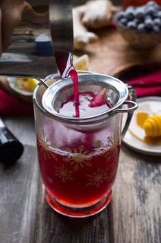 a pitcher filled with liquid sitting on top of a wooden table