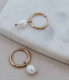 Have the option of two styles in one earring set! Swap out the pearls for the 18K gold hoops for a second look, waterproof and perfect for any occasion. Length: 11/4" Pear Charm 18k Gold plated Waterproof Non-tarnishing Hypoallergenic Care tips: Store jewelry in a small plastic zip lock Use a jewelry cloth to clean everyday oils off Avoid contact with chemicals such as hairspray, lotions, perfumes, etc. Gold Hypoallergenic Pearl Huggie Earrings, Gold Hypoallergenic Pearl Hoop Earrings, One Earring, Store Jewelry, Pearl Charms, Gold Hoops, Charm Earrings, Earring Set, Pear