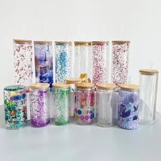 there are many different colored sprinkles in glass jars