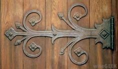 an ornate iron design on the side of a wooden door