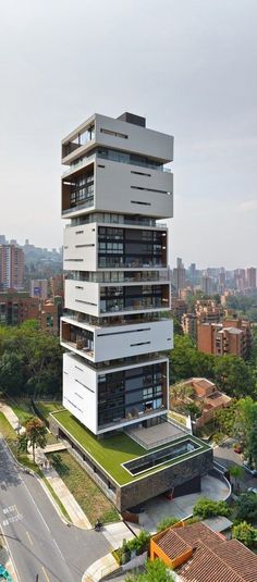 a tall building with balconies on top of it next to a parking lot