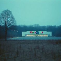 an empty building with the word toys written on it's side in front of trees